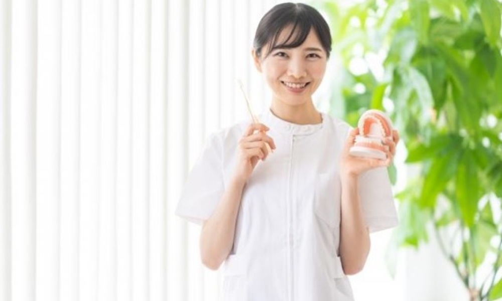 歯磨きを持つ歯科衛生士